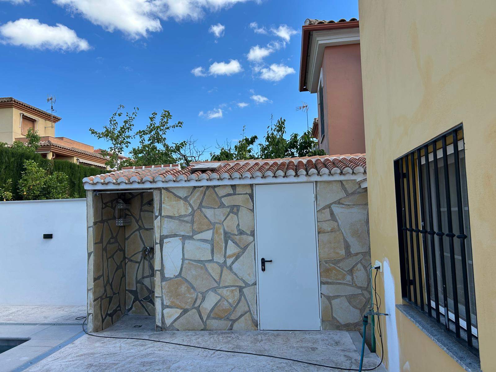 Caseta auxiliar con revestimiento de piedra natural y teja árabe